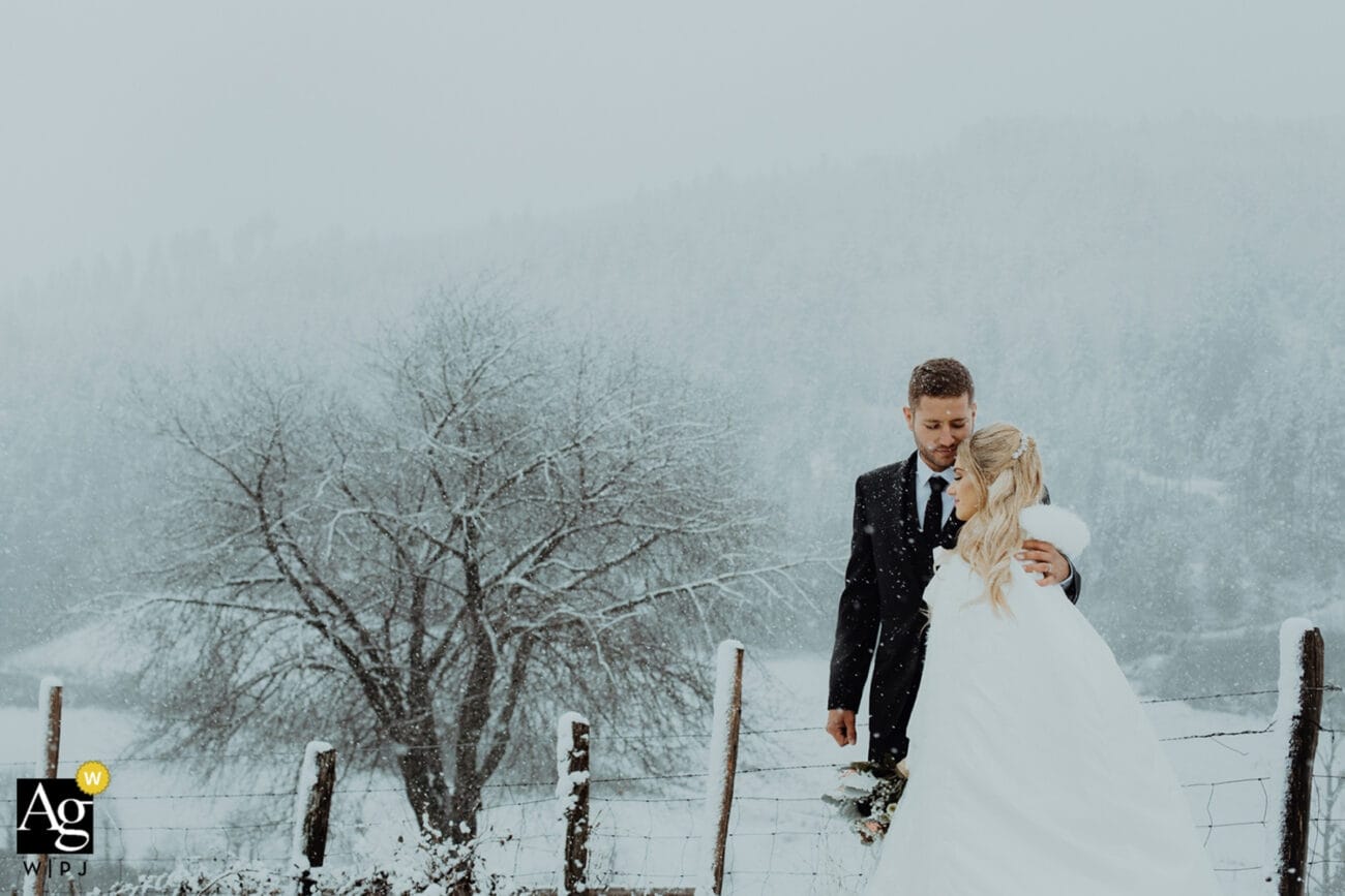 Couple de mariés dans les Alpes françaises, enlacés sous la neige dans un paysage d’hiver romantique.