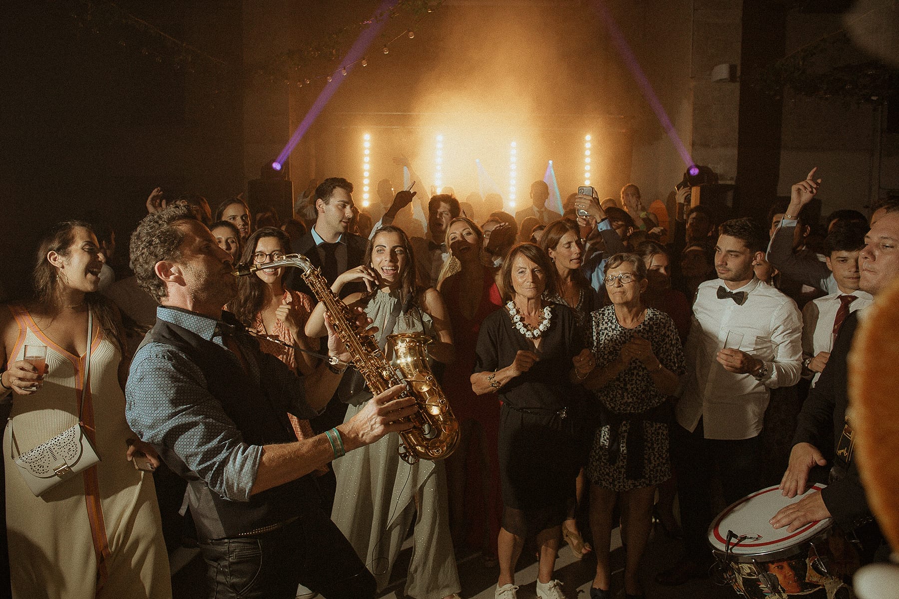 Invités faisant la fête autour d’un musicien pendant un mariage. enjoy your wedding day