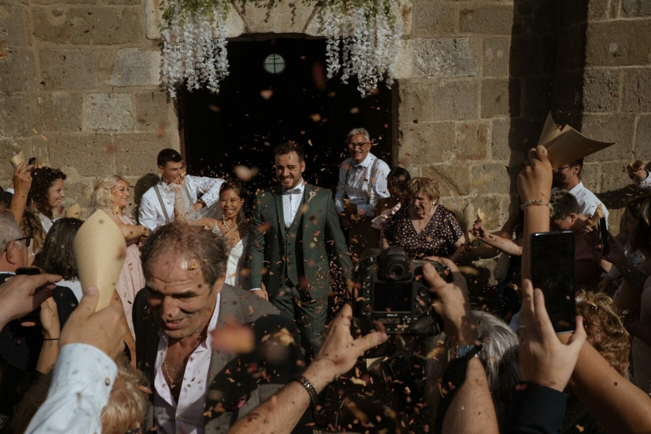 Sortie de cérémonie des mariés sous une pluie de pétales, photographiée à Lyon par un photographe de mariage en style reportage