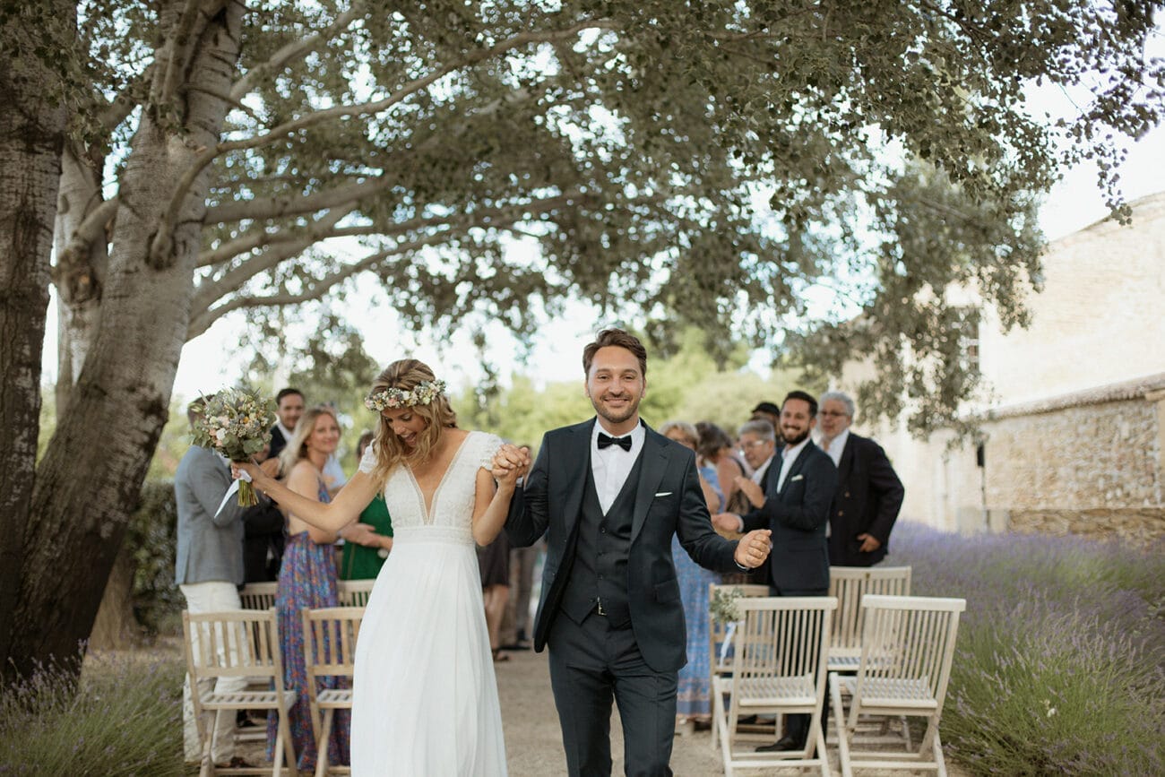 Sortie de cérémonie laïque en extérieur, mariés main dans la main sous les arbres, photo prise à Lyon par un photographe de mariage