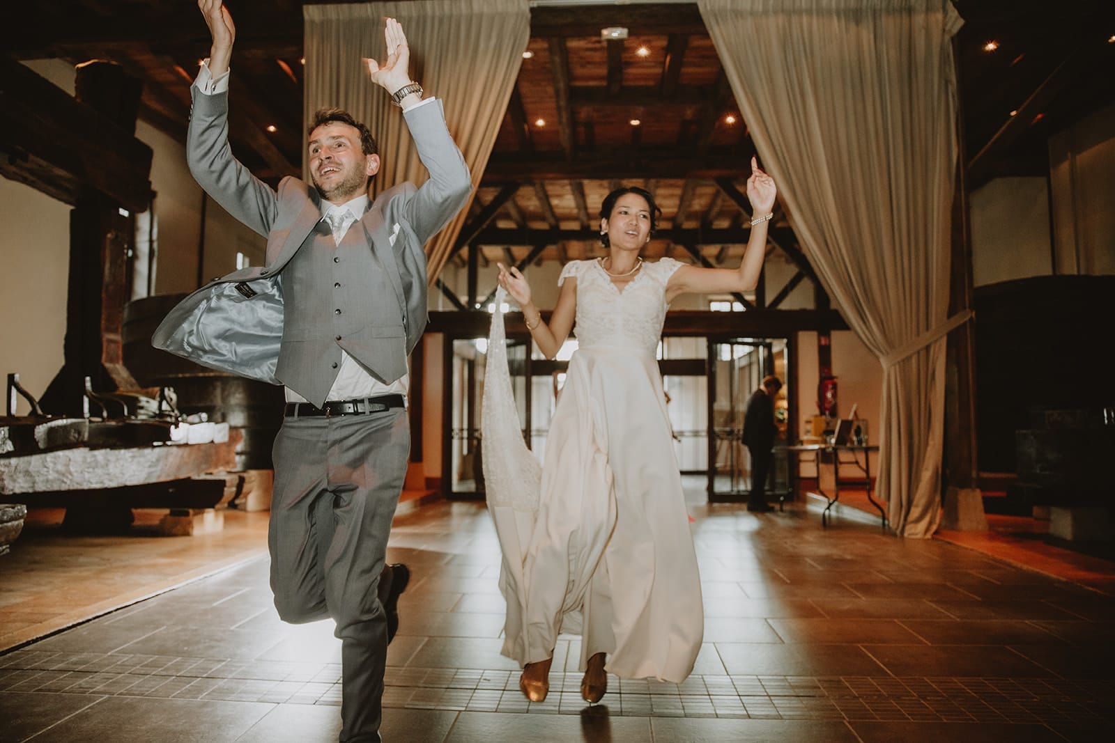 Les mariés font une entrée pleine d’énergie dans la salle de réception du Château de Pizay, sous les applaudissements