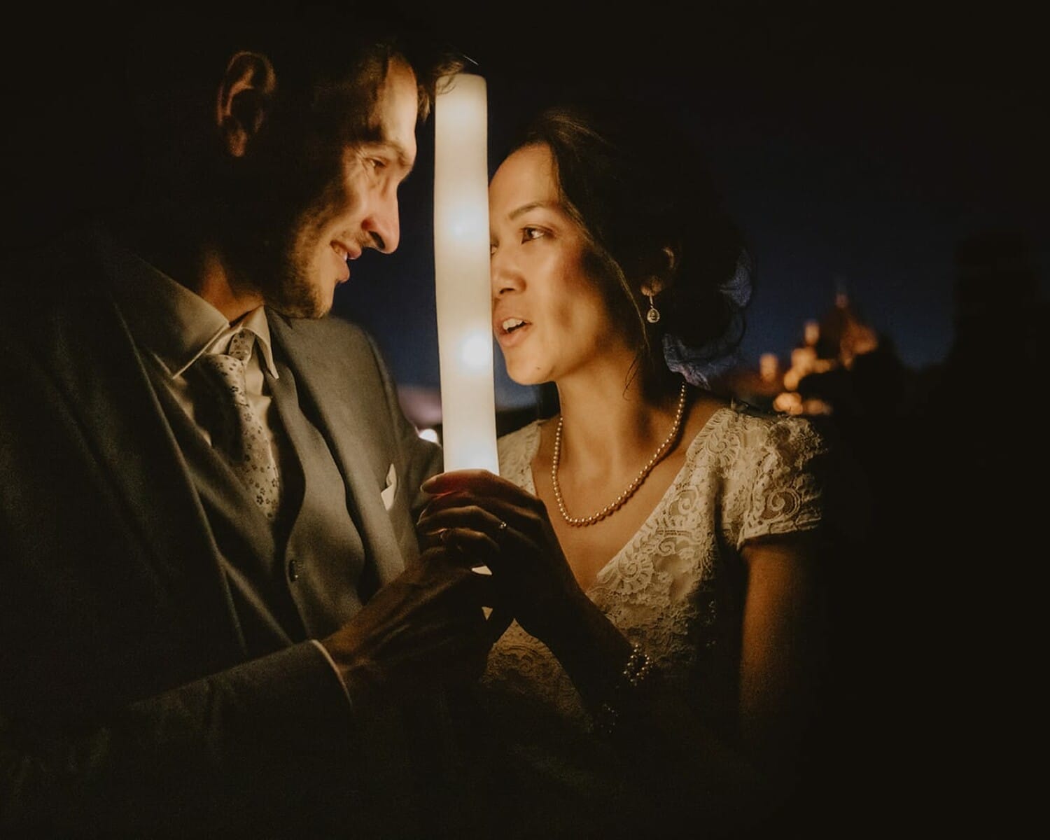Couple de mariés se regardant à la lumière d’une lanterne, lors d’un mariage au Château de Pizay