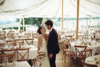 Bride and groom sharing a quiet moment before dinner under a beautifully decorated tent