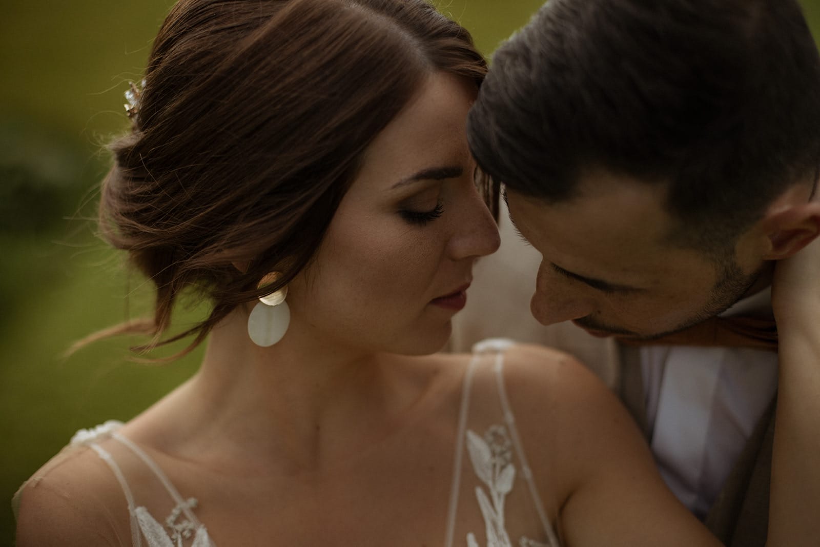 Portrait intime de mariés se frôlant tendrement le visage, plongés dans un moment suspendu juste après la cérémonie.