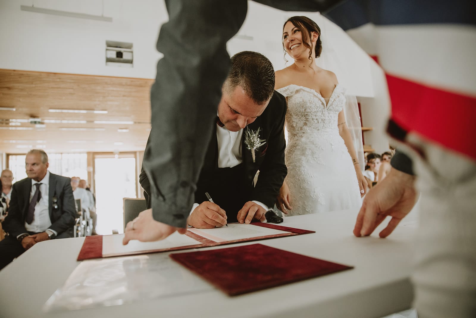 Mariage civil dans la région du Beaujolais – signature du registre à la mairie, sous le regard souriant de la mariée