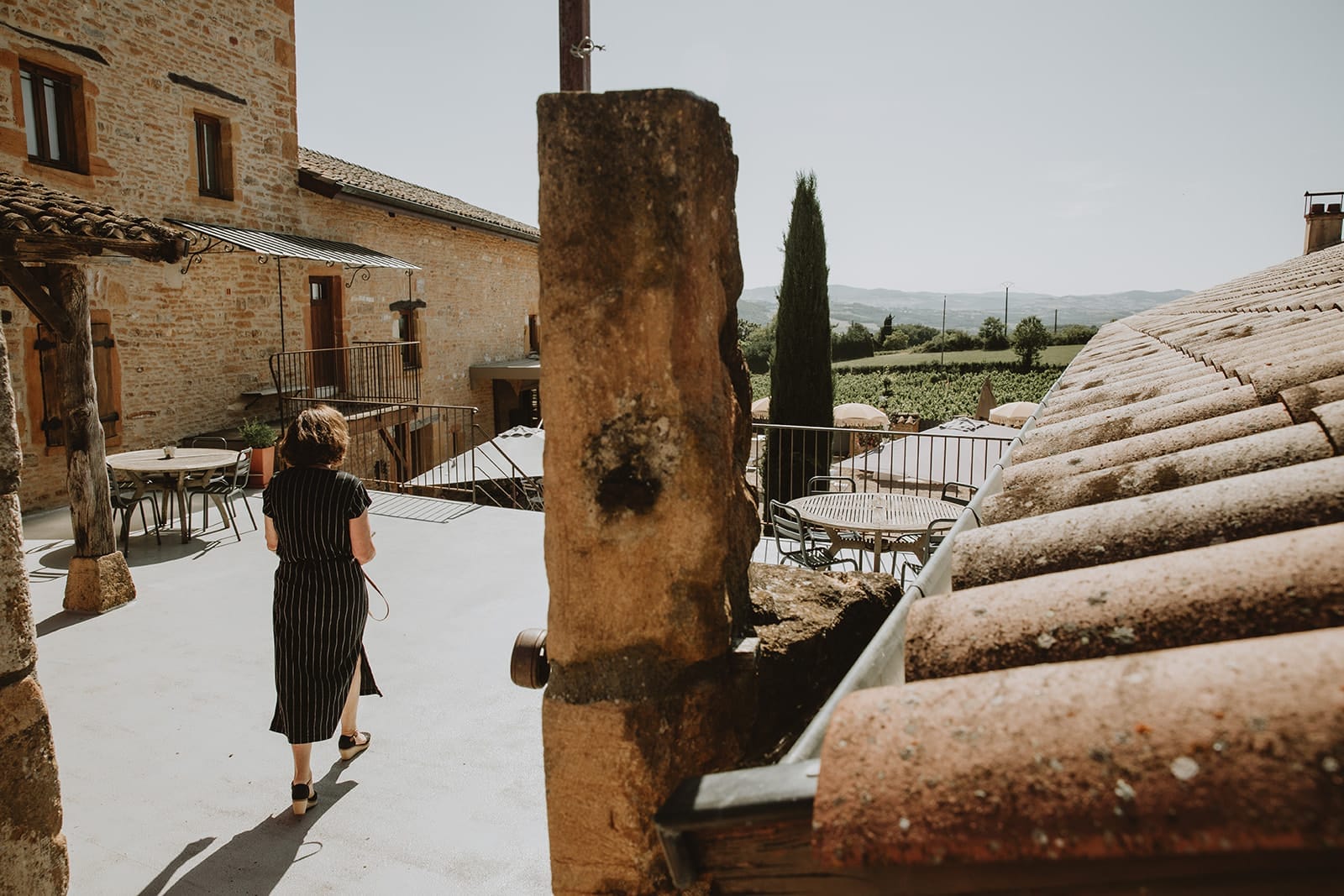 Vue sur la terrasse en pierres dorées du domaine La Cour Dorée à Charnay, avec les vignes en arrière-plan